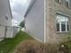Side view of the home displaying siding and a brick corner with nearby white fencing at 317 Legacy Blvd, Greenwood, IN 46143