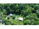 Aerial view of property featuring a house, outbuilding, lush greenery, and surrounded by dense trees at 3282 S Conservation Club Rd, Morgantown, IN 46160