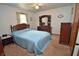 Cozy bedroom with carpet, a blue bedspread, and a wooden dresser at 3282 S Conservation Club Rd, Morgantown, IN 46160