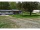 Gray home features a gravel driveway leading up to the house, complemented by a large green tree at 3282 S Conservation Club Rd, Morgantown, IN 46160