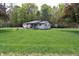 Charming single-story home with a lush lawn and attached garage nestled amongst mature trees and a front porch swing at 3282 S Conservation Club Rd, Morgantown, IN 46160
