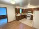 Functional kitchen with ample cabinet space, a white range, and a connecting dining area at 3282 S Conservation Club Rd, Morgantown, IN 46160