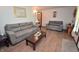 Cozy living room featuring a large gray sofa, a loveseat, and laminate wood flooring at 3282 S Conservation Club Rd, Morgantown, IN 46160
