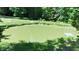 Scenic view of a tranquil pond with grassy shoreline and a small dock, surrounded by lush greenery at 3282 S Conservation Club Rd, Morgantown, IN 46160