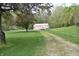 A large, well-kept outbuilding with a gravel driveway and fencing, nestled in a scenic yard at 3282 S Conservation Club Rd, Morgantown, IN 46160