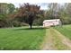 Outbuilding with gravel driveway and green yard, surrounded by trees, offering a peaceful setting at 3282 S Conservation Club Rd, Morgantown, IN 46160