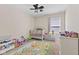 Bright bedroom with a crib, ceiling fan, and neutral walls at 3311 Stoddard Pl, Indianapolis, IN 46217
