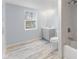 Bright bathroom with a tub, shower, modern vanity, toilet, and a large window at 3331 Graceland Ave, Indianapolis, IN 46208