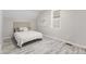 This bedroom boasts wood floors, a window, and a comfy bed with a tufted headboard at 3331 Graceland Ave, Indianapolis, IN 46208