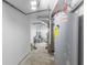 Basement utility room showing a water heater, exposed pipes, and concrete floor at 3331 Graceland Ave, Indianapolis, IN 46208