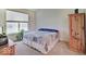 Relaxing bedroom featuring a comfortable bed, a natural wood cabinet, and a view of a tree-filled backyard at 3480 Limelight Ln, Whitestown, IN 46075