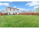 Large backyard with well-maintained lawn, stone firepit, patio area, hot tub, and wood fence at 401 Shadetree Ln, Sheridan, IN 46069