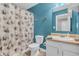 Bathroom with white vanity, toilet, and shower with gray floral shower curtain at 401 Shadetree Ln, Sheridan, IN 46069