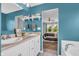 Blue bathroom, double vanity, mirror, and view to bedroom with wooden floors at 401 Shadetree Ln, Sheridan, IN 46069