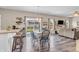 Modern dining area featuring wood floors, bar seating, and view into the backyard at 401 Shadetree Ln, Sheridan, IN 46069