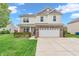 Inviting two-story home with a brick-accented facade, manicured lawn, and attached two-car garage at 401 Shadetree Ln, Sheridan, IN 46069