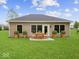 Backyard with a green lawn and patio with wooden outdoor table and chairs at 403 Fox Ridge Ct, Shelbyville, IN 46176