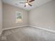 An empty bedroom with carpet, neutral paint, baseboard trim, and a ceiling fan at 403 Fox Ridge Ct, Shelbyville, IN 46176