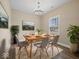 A dining room with a light wood table set for a meal, modern chairs, and a neutral rug, complemented by plants at 403 Fox Ridge Ct, Shelbyville, IN 46176