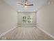 An empty room with neutral walls and carpet, and a ceiling fan, with natural light streaming through the window, a blank canvas at 403 Fox Ridge Ct, Shelbyville, IN 46176