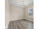 An empty room featuring hardwood floors and natural light streaming through the window, with a decorative chandelier at 403 Fox Ridge Ct, Shelbyville, IN 46176