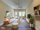 A well-lit living room with a modern sofa, accent chairs, a striped rug, and a ceiling fan for comfortable living at 403 Fox Ridge Ct, Shelbyville, IN 46176