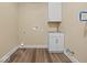 White utility sink, cabinet and upper cabinet in utility room with wood look flooring at 403 Fox Ridge Ct, Shelbyville, IN 46176