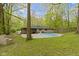 A stone-clad home sits next to an inground pool in a wooded lot with plenty of privacy at 4475 Berkshire Rd, Indianapolis, IN 46226