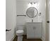 Clean bathroom with floating vanity, white walls, black hardware, and circular mirror at 4475 Berkshire Rd, Indianapolis, IN 46226