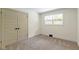 Bedroom features neutral carpet, white trim, and a view to trees outside the window at 4475 Berkshire Rd, Indianapolis, IN 46226