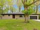 Charming single-story home featuring stone facade, attached garage, and mature trees at 4475 Berkshire Rd, Indianapolis, IN 46226