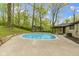 A bright blue inground pool is surrounded by a concrete patio and mature shade trees at 4475 Berkshire Rd, Indianapolis, IN 46226