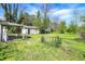 Large backyard enclosed by chain-link fence, featuring a detached garage, and mature trees at 4941 Mathews Ave, Indianapolis, IN 46227