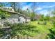 Side yard with siding, mature trees, and a glimpse of backyard features a shed and chain-link fence at 4941 Mathews Ave, Indianapolis, IN 46227
