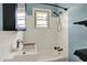 Bright bathroom with a shower-tub combo, updated fixtures, and natural light from a window at 4941 Mathews Ave, Indianapolis, IN 46227