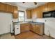 Open kitchen with vinyl floors, oak cabinets, and a stainless steel microwave at 4941 Mathews Ave, Indianapolis, IN 46227
