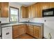 Open kitchen with wood cabinetry, a stainless sink and faucet, and vinyl flooring at 4941 Mathews Ave, Indianapolis, IN 46227