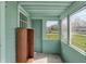 Enclosed porch with mint green siding, an outdoor view, and bright natural light at 4941 Mathews Ave, Indianapolis, IN 46227