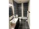 Contemporary bathroom featuring black tile, a sleek vanity, and modern fixtures at 4984 W 59Th St, Indianapolis, IN 46254