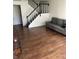 Inviting living room with hardwood flooring, a gray sofa, and staircase at 4984 W 59Th St, Indianapolis, IN 46254