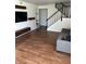 Spacious living room featuring wood floors, modern decor and an open staircase at 4984 W 59Th St, Indianapolis, IN 46254