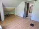 Attic featuring wood floors, slanted ceilings, and an open door into the room at 5103 W Vermont St, Indianapolis, IN 46224