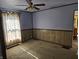 Living room featuring light blue walls, carpet floors, and bright light from the window at 5103 W Vermont St, Indianapolis, IN 46224