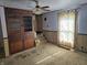 Living room featuring tan carpet, wood paneling, and a ceiling fan light fixture at 5103 W Vermont St, Indianapolis, IN 46224