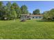 Back of house featuring an open lawn, scattered trees, and ample green space at 5103 W Vermont St, Indianapolis, IN 46224