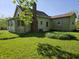 Rear exterior showcasing a spacious yard and house with vinyl siding at 5103 W Vermont St, Indianapolis, IN 46224