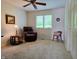 Cozy bedroom features soft carpet, a ceiling fan, and a comfortable recliner next to a window offering natural light at 515 E Hoover Dr, Nineveh, IN 46164