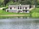 Charming lakefront home with large windows, inviting deck, and lush green lawn at 515 E Hoover Dr, Nineveh, IN 46164