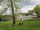 Charming home with two Adirondack chairs overlooking the tranquil lake, framed by lush greenery and a well-kept lawn at 515 E Hoover Dr, Nineveh, IN 46164