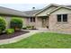 Close-up view of the brick front entrance, adorned with lush greenery and a well-maintained lawn at 515 E Hoover Dr, Nineveh, IN 46164